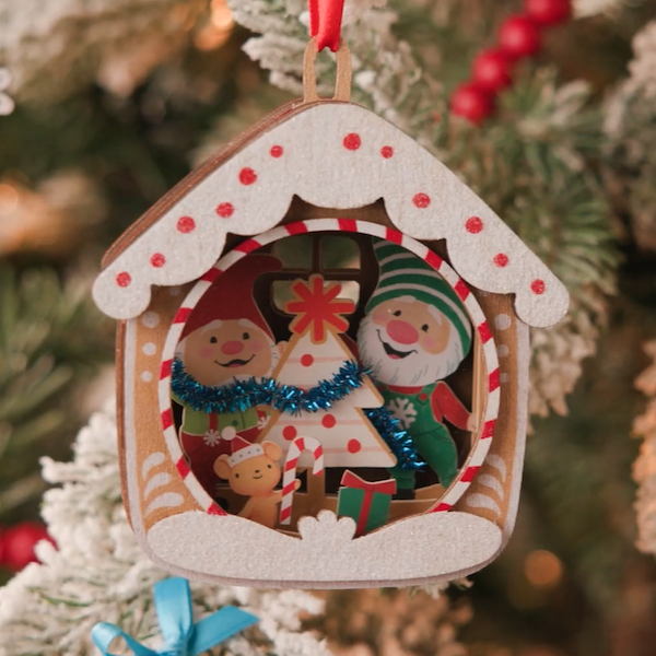 A Keepsake Ornament featuring gnomes Gnaughty and Gnice, rendered in a wood and dimensional paper craft construction.